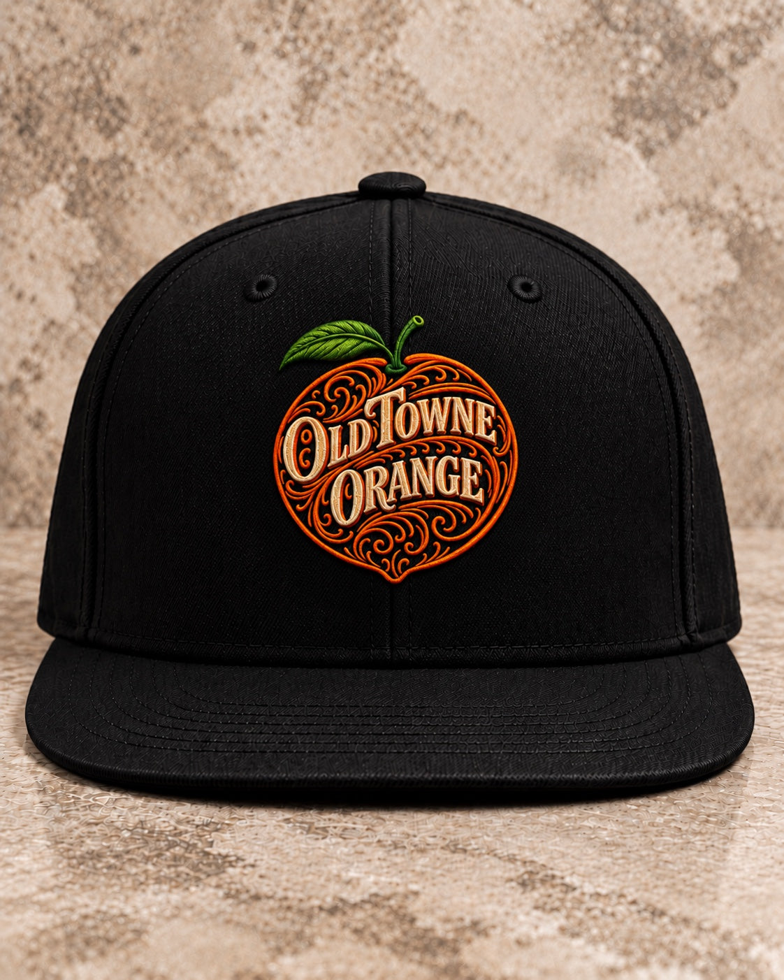 OLDTWN black solid-back flat-bill snapback with ornate orange fruit and Old Towne Orange embroidery