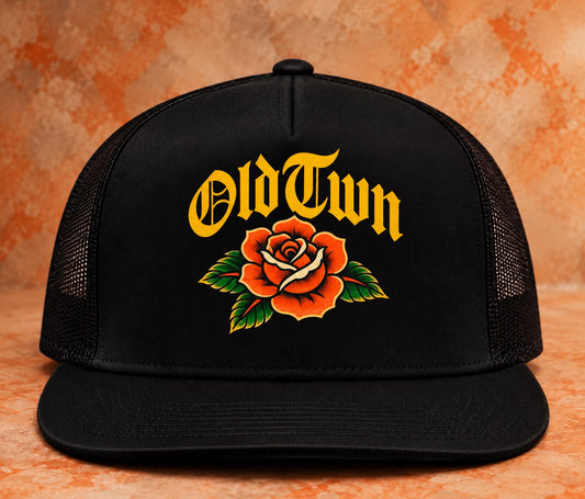 Black OLDTWN flat-bill mesh snapback with gold OldTwn lettering and rose full-color graphic print, front view